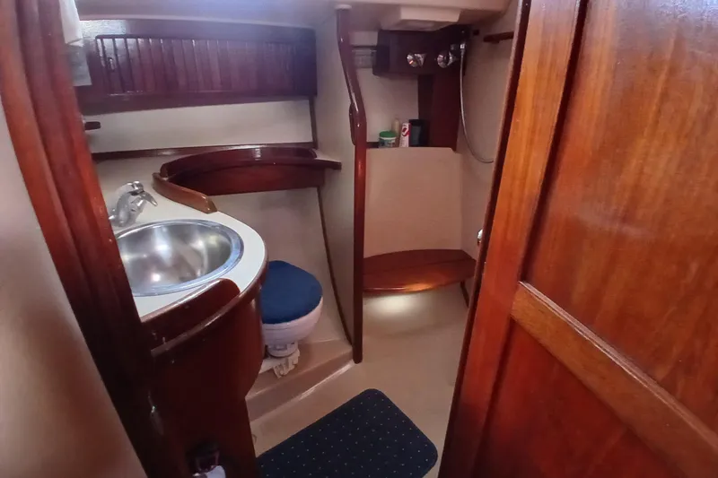 Slide: The Image of 1995 Island Packet 37 yacht bathroom with wooden cabinetry and stainless steel sink. - 28
