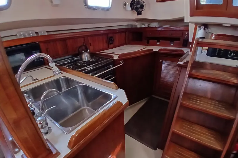 Slide: The Image of 1995 Island Packet 37 yacht kitchen with wooden cabinetry and stainless steel sink. - 31