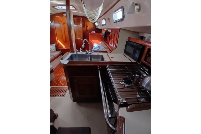 Slide: The Image of Interior of 1995 Island Packet 37 sailboat featuring kitchen and wooden cabinetry. - 35