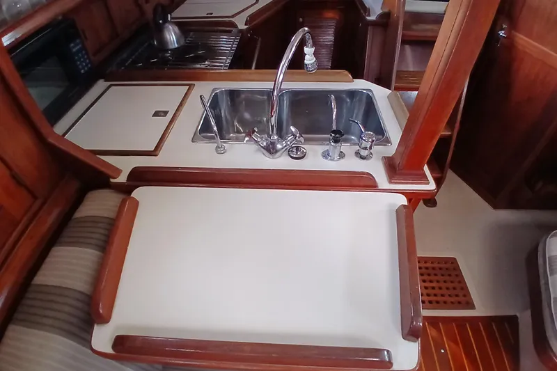 Slide: The Image of Interior of 1995 Island Packet 37 sailboat featuring a compact kitchen sink area. - 38