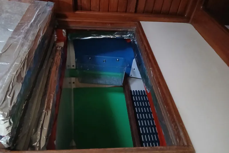 Slide: The Image of Engine compartment of a 1995 Island Packet 37 sailboat, featuring insulation and wooden framing. - 41