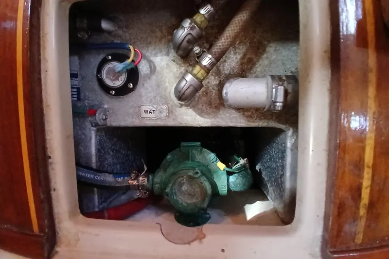 Slide: The Image of 1995 Island Packet 37 sailboat engine compartment with visible wiring and plumbing components. - 44
