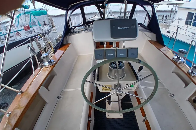 Slide: The Image of Cockpit of 1995 Island Packet 37 sailboat with steering wheel and navigation equipment. - 46