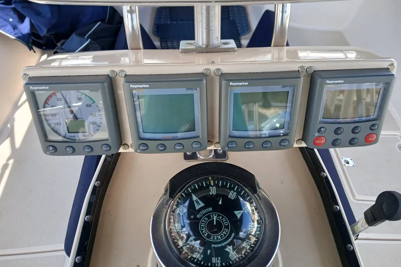 Slide: The Image of Cockpit instruments on a 1995 Island Packet 37 sailboat, featuring Raymarine displays and compass. - 48
