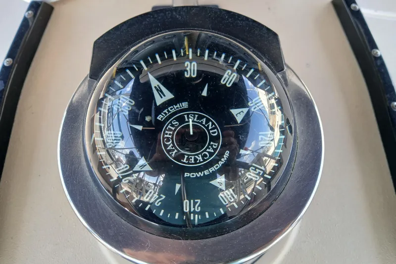 Slide: The Image of Compass on 1995 Island Packet 37 yacht, displaying cardinal directions and degrees. - 49