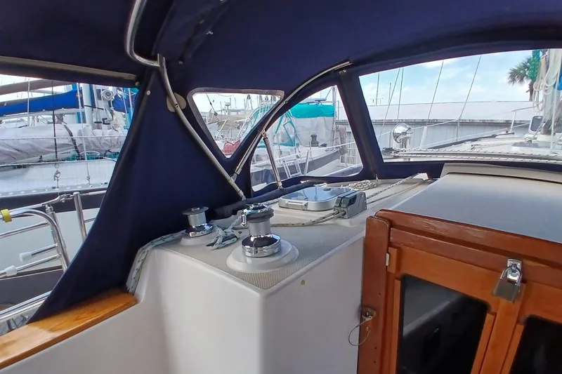Slide: The Image of 1995 Island Packet 37 sailboat cockpit with winches and wooden hatch. - 51