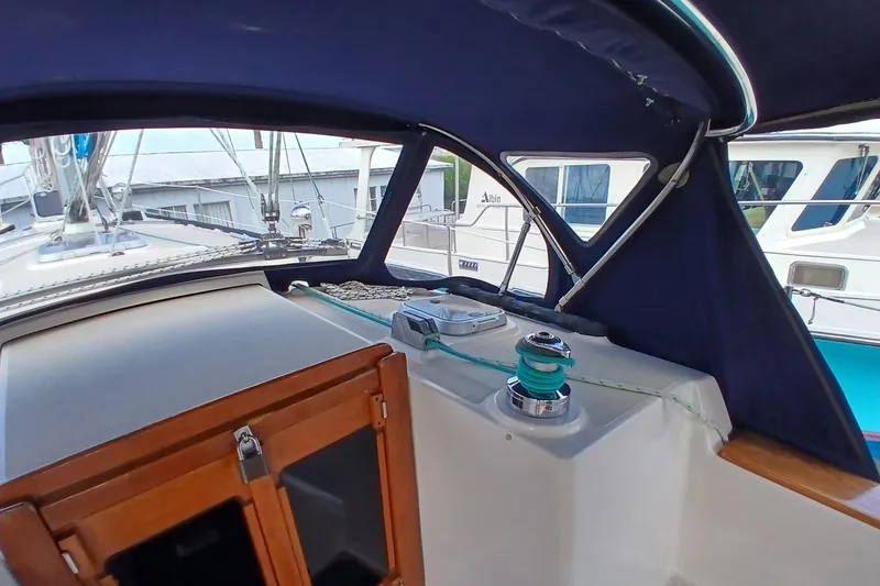 Slide: The Image of 1995 Island Packet 37 sailboat cockpit with blue canopy and winch. - 52