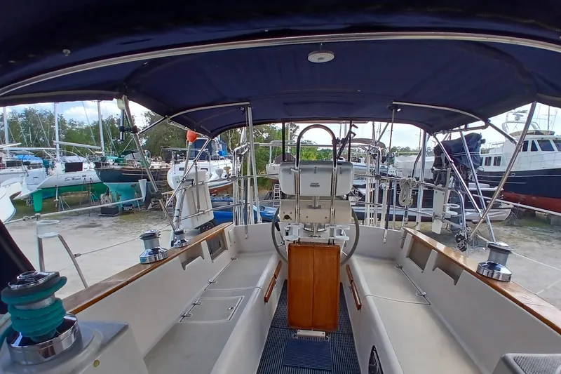 Slide: The Image of Cockpit view of a 1995 Island Packet 37 sailboat, featuring a covered helm and seating area. - 53