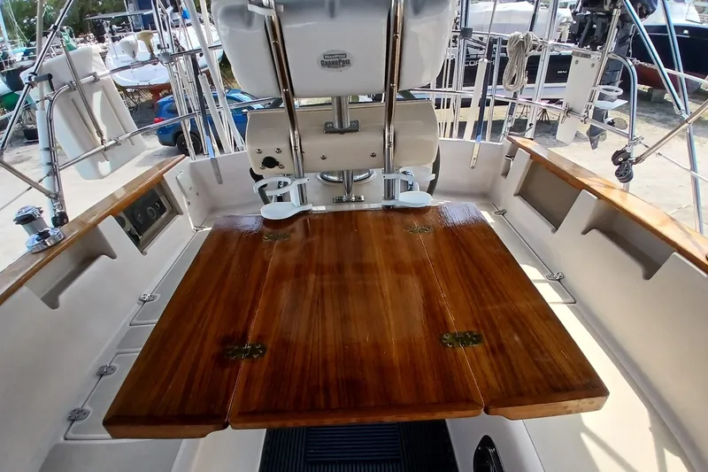 Slide: The Image of Cockpit of 1995 Island Packet 37 sailboat with wooden table and steering equipment. - 55