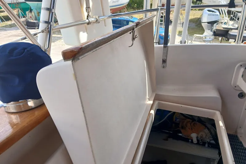 Slide: The Image of 1995 Island Packet 37 sailboat cockpit storage area with open hatch and visible equipment. - 56