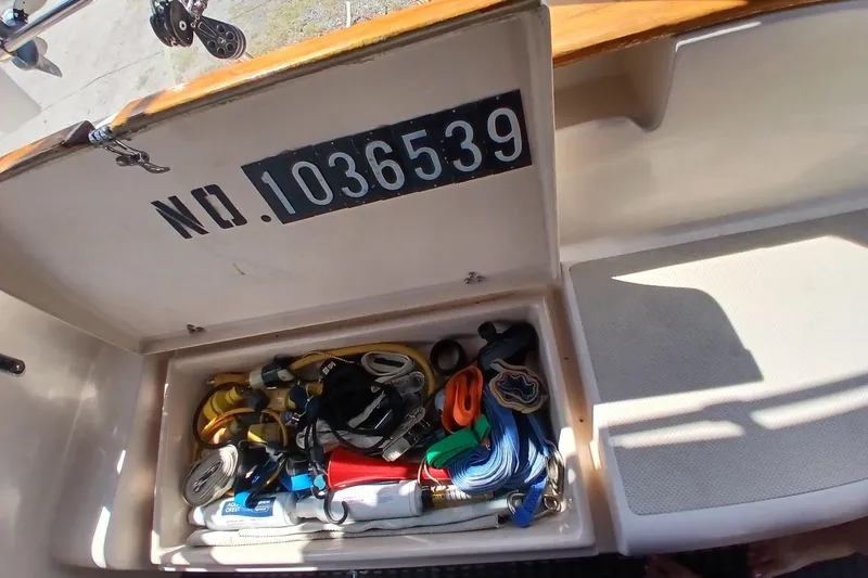 Slide: The Image of Storage compartment on a 1995 Island Packet 37 sailboat, containing various nautical gear. - 58