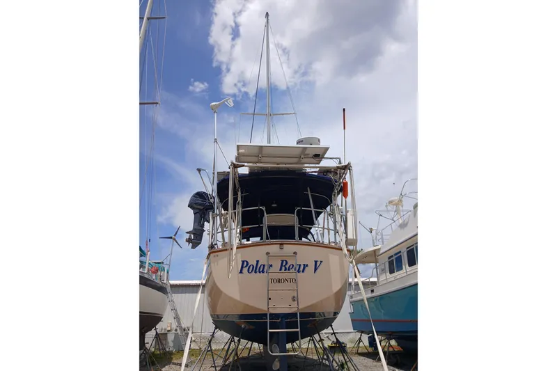 Slide: The Image of 1995 Island Packet 37 sailboat, named "Polar Bear V," docked in a marina. - 59