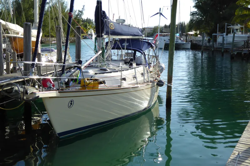 Slide: The Image of 1995 Island Packet 37 sailboat docked in a serene marina setting. - 6