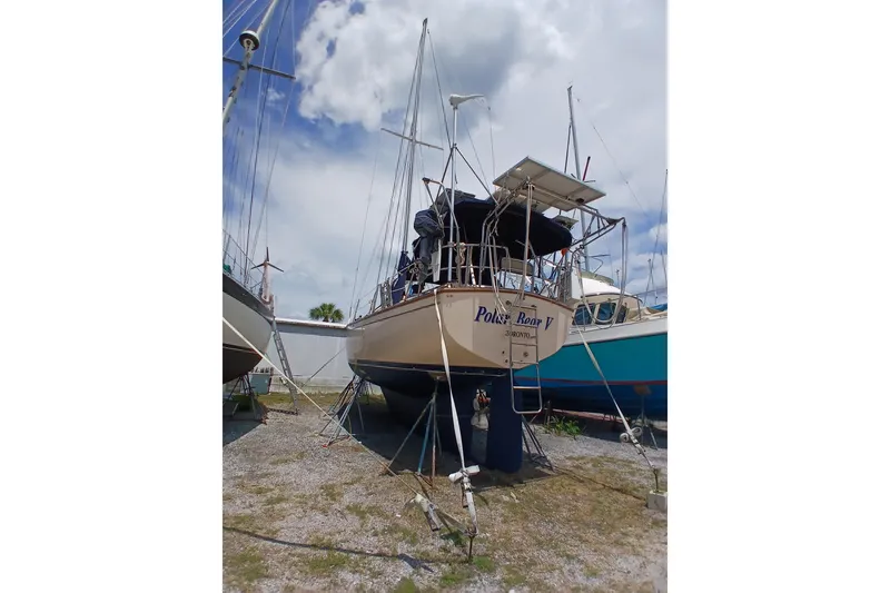 Slide: The Image of 1995 Island Packet 37 sailboat on dry dock under a cloudy sky. - 60