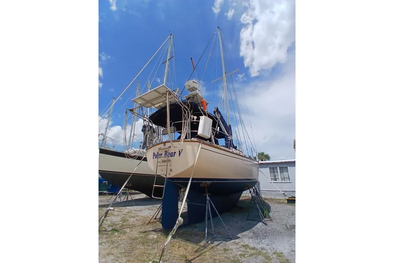 Slide: The Image of 1995 Island Packet 37 sailboat on stands, under a clear blue sky. - 61