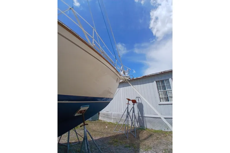 Slide: The Image of 1995 Island Packet 37 sailboat on stands, blue sky background. - 64