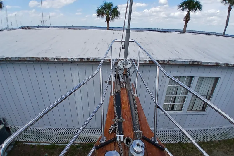 Slide: The Image of Bow of 1995 Island Packet 37 sailboat with palm trees and building in background. - 69