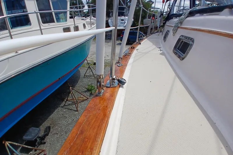 Slide: The Image of 1995 Island Packet 37 sailboat deck with polished wood and metal fittings. - 73