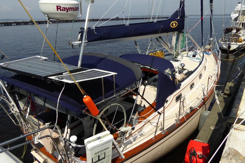 Slide: The Image of 1995 Island Packet 37 sailboat docked, featuring solar panels and Raymarine equipment. - 75