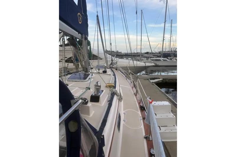 Slide: The Image of 1995 Island Packet 37 sailboat docked at marina, showcasing deck and rigging. - 76