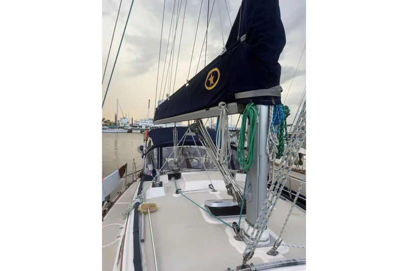 Slide: The Image of 1995 Island Packet 37 sailboat docked, featuring rigging and covered mainsail. - 81
