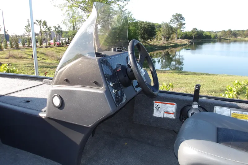 Slide: The Image of Interior view of 2026 Tracker Bass Tracker Classic XL boat cockpit by a lake. - 5