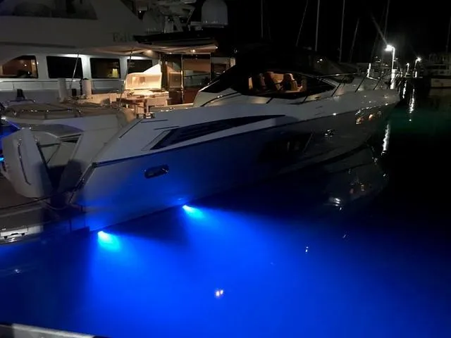 Slide: The Image of 2011 Sunseeker 64 Predator yacht with blue underwater lights at night. - 22