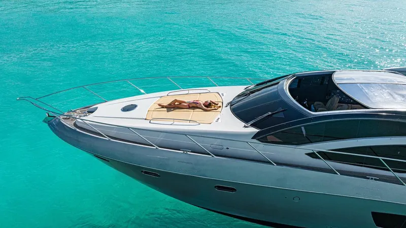 Slide: The Image of 2011 Sunseeker 64 Predator yacht on turquoise water, person sunbathing on deck. - 3