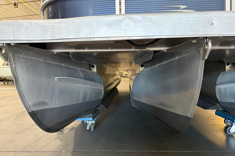 Slide: The Image of 2023 Bennington S22 pontoon boat underside view in a warehouse setting. - 10