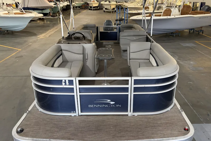 Slide: The Image of 2023 Bennington S22 pontoon boat with spacious seating in a showroom. - 16