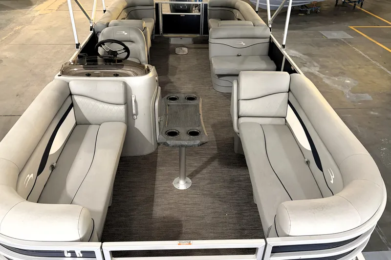 Slide: The Image of 2023 Bennington S22 pontoon boat interior with plush seating and steering console. - 17
