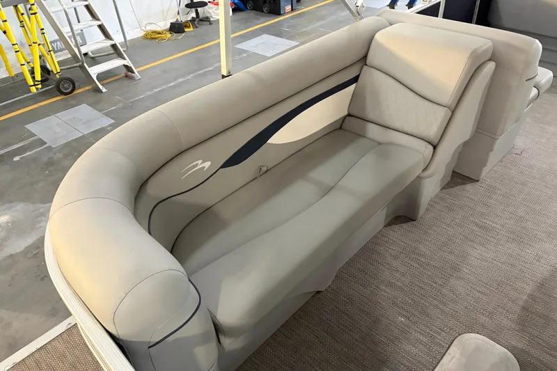 Slide: The Image of 2023 Bennington S22 boat interior with plush seating in a workshop setting. - 27