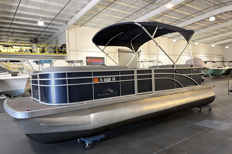 Slide: The Image of 2023 Bennington S22 pontoon boat in a showroom with Yamaha signage. - 4