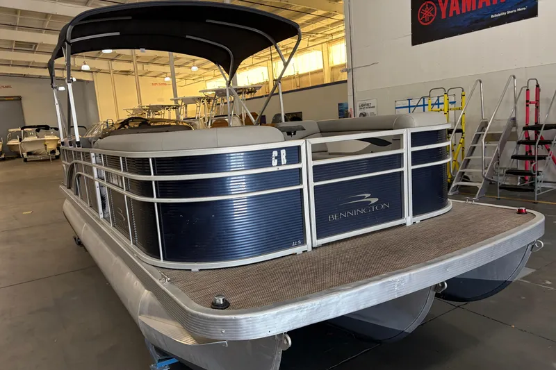 Slide: The Image of 2023 Bennington S22 pontoon boat in showroom, featuring sleek design and spacious deck. - 8