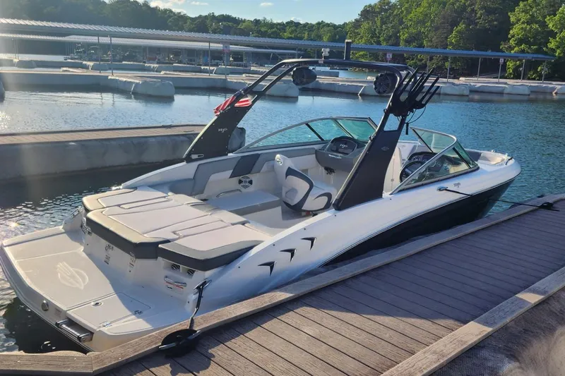 Slide: The Image of 2019 Chaparral 23 H2O Sport boat docked at a marina under sunny skies. - 12
