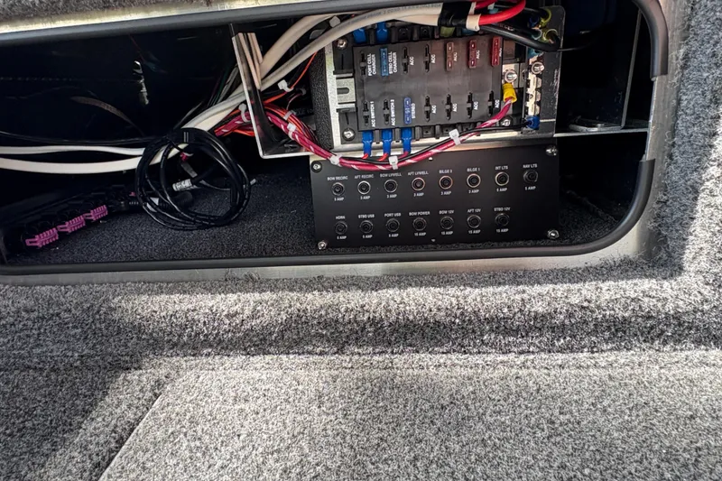 Slide: The Image of Electrical panel inside 2026 Lund 2075 Pro-V Sport boat, showcasing wiring and fuse box. - 16