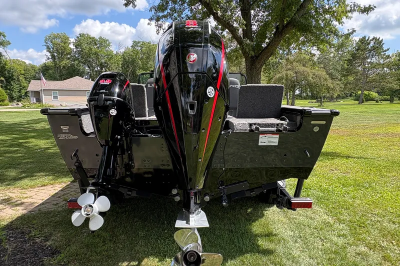 Slide: The Image of 2026 Lund 2075 Pro-V Sport boat with dual outboard motors on grassy lawn. - 3