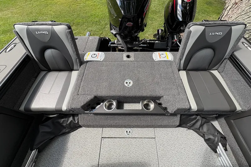 Slide: The Image of 2026 Lund 2075 Pro-V Sport boat interior with cushioned seating and dual outboard motors. - 33