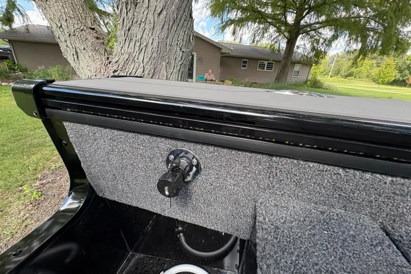 Slide: The Image of 2026 Lund 2075 Pro-V Sport boat interior detail with carpeted panel and control knob. - 38