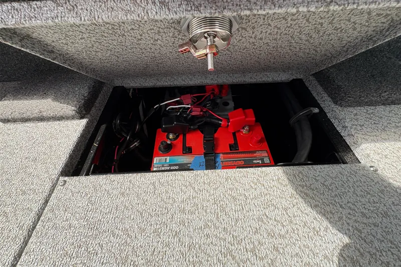 Slide: The Image of Battery compartment of 2026 Lund 2075 Pro-V Sport boat, showcasing red battery and wiring. - 43