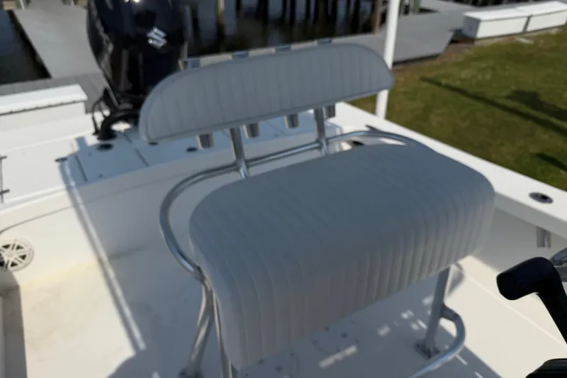 Slide: The Image of White cushioned seat on 2021 Intruder 23 boat, docked near water. - 18