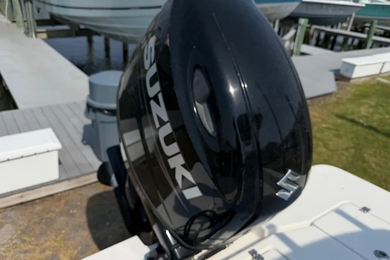 Slide: The Image of Black Suzuki outboard motor on a 2021 Intruder 23 boat at a dock. - 25