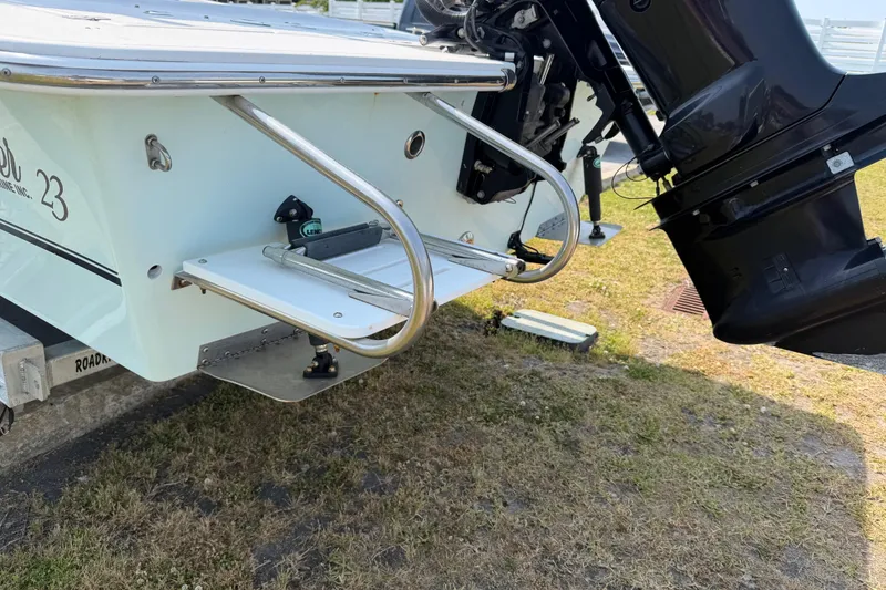 Slide: The Image of 2021 Intruder 23 boat stern with motor and swim platform on grass. - 32