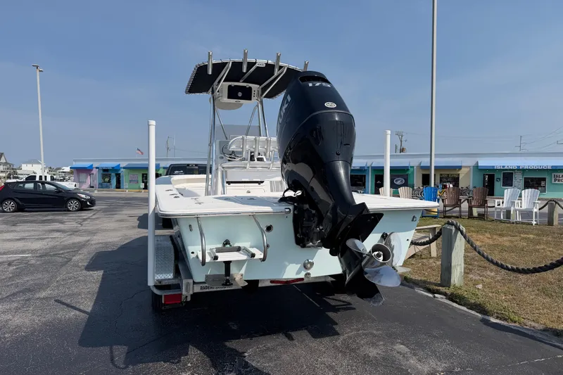 Slide: The Image of 2021 Intruder 23 boat with outboard motor parked in a lot near shops. - 5