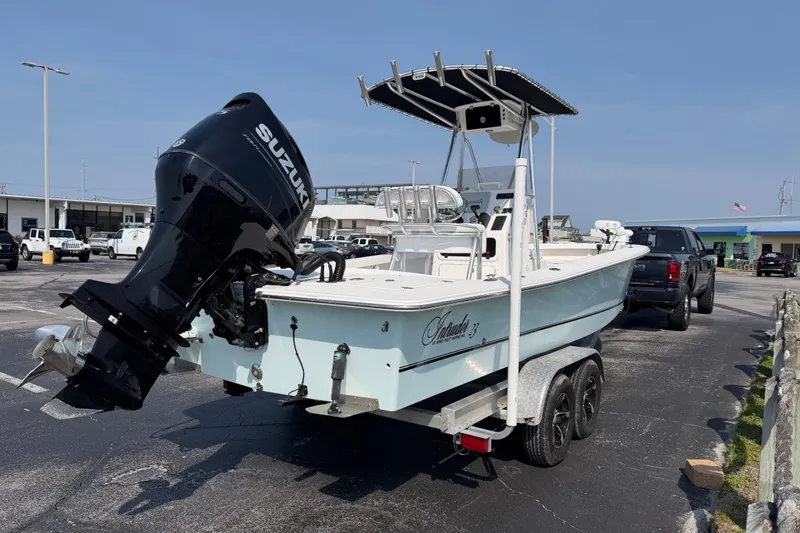 Slide: The Image of 2021 Intruder 23 boat on trailer with Suzuki outboard motor in parking lot. - 6