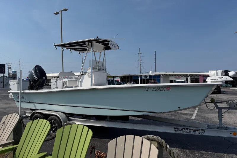 Slide: The Image of 2021 Intruder 23 boat on trailer in parking lot, featuring Suzuki outboard motor. - 9