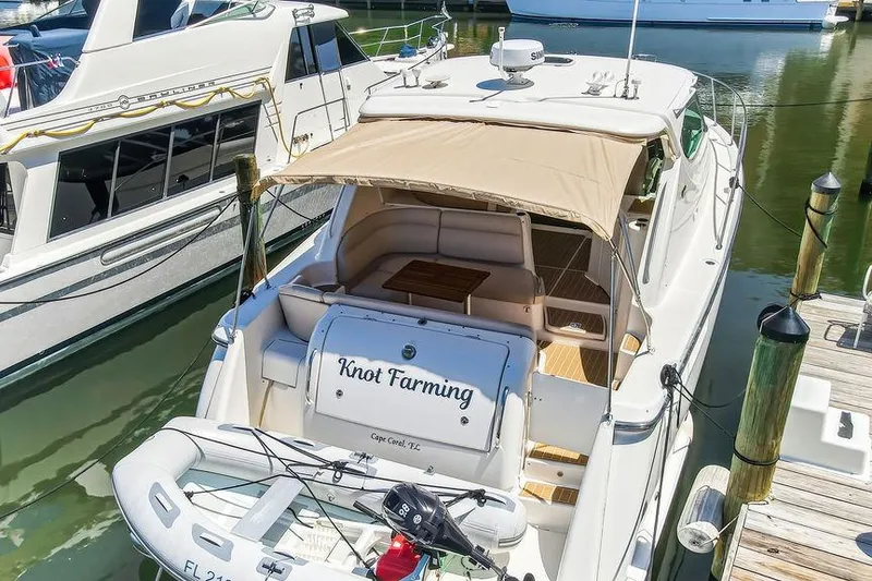 Slide: The Image of 2008 Tiara Yachts 3900 Sovran docked, featuring "Knot Farming" name and inflatable boat. - 10