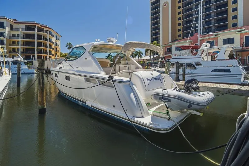 Slide: The Image of 2008 Tiara Yachts 3900 Sovran docked at marina with modern buildings in background. - 15
