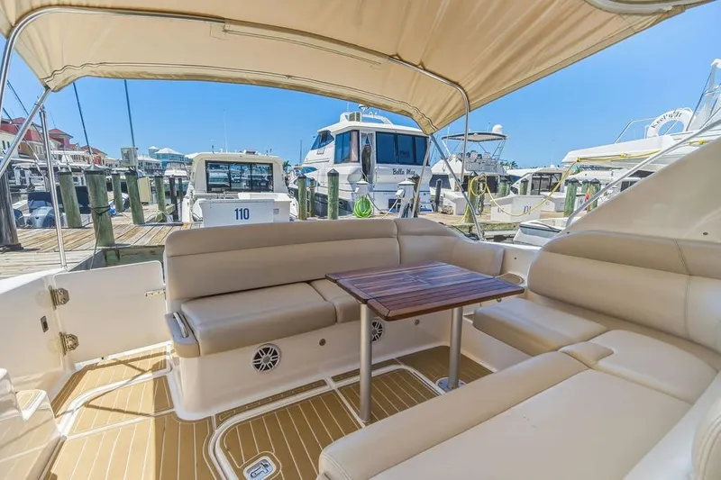 Slide: The Image of 2008 Tiara Yachts 3900 Sovran interior with beige seating and wooden table at marina. - 18