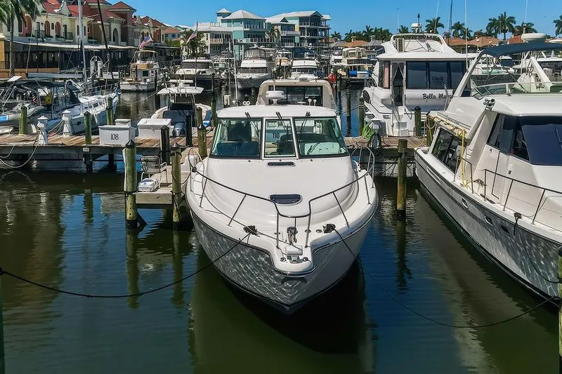 Slide: The Image of 2008 Tiara Yachts 3900 Sovran docked in a bustling marina, surrounded by other boats. - 2